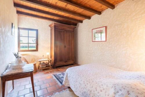 1 dormitorio con cama y techo de madera en Maison de maître landaise, Bastide d'Armagnac en Lacquy