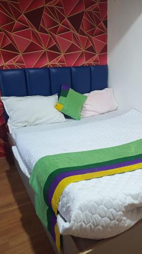 アーメダバードにあるHotel Sawariyaのカラフルなシーツと枕が備わるベッド1台