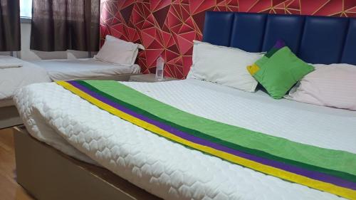 a large bed with a colorful blanket on it at Hotel Sawariya in Ahmedabad