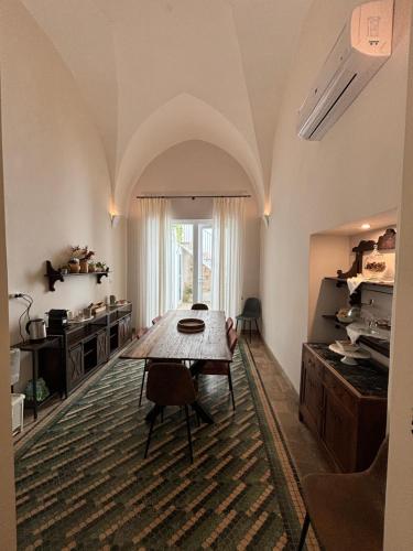 ein Esszimmer mit einem Tisch und einer Küche in der Unterkunft B&B Antica Dimora dell'Angelo in Nardò