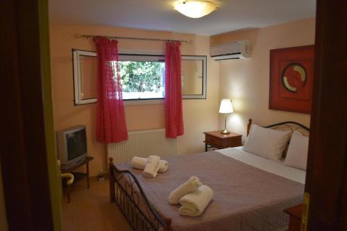 - une chambre avec un lit et des serviettes dans l'établissement Villa Maria, à Porto Heli