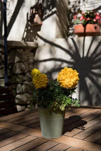 a vase with yellow flowers sitting on a table at In Provence Hôtel - Expérience Authentique in Venelles