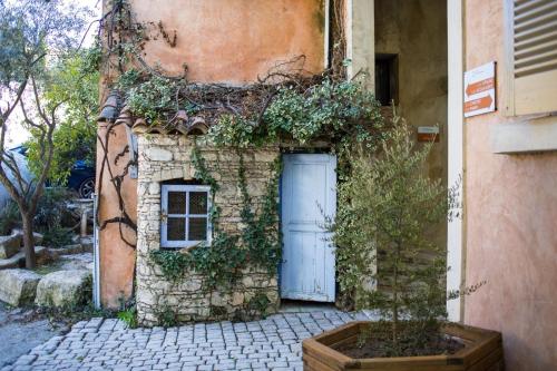 a stone building with a door and a window at In Provence Hôtel - Expérience Authentique in Venelles