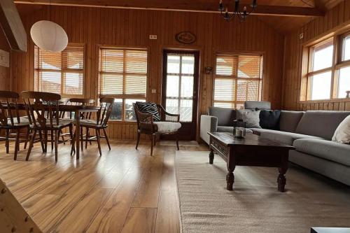 a living room with a couch and a table at Cozy Cabin near Golden Circle - Private Hot Tub in Kotströnd