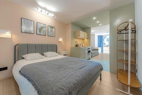 1 Schlafzimmer mit einem großen Bett und einer Küche in der Unterkunft Newly renovated studio 2 min from Playa La Arena in Puerto de Santiago
