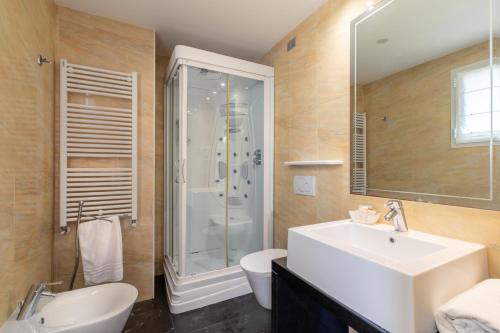 bagno con lavandino, doccia e servizi igienici di Hotel Villa Doimo a Lignano Sabbiadoro