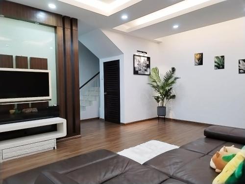 a living room with a flat screen tv and a couch at 13Pax -2 Storey Bayu Mutiara Bukit Mertajam Penang in Bukit Mertajam