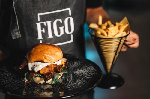 a person holding a plate with a sandwich and fries at Noba Hotel e Residenze in Rome