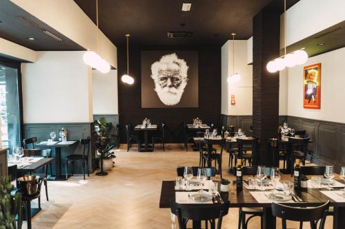 a restaurant with tables and chairs and a picture of a man at Noba Hotel e Residenze in Rome