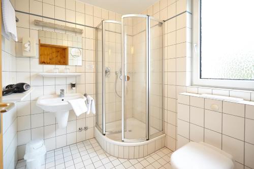 een badkamer met een douche en een wastafel bij Hotel Sonne in Bad Homburg vor der Höhe