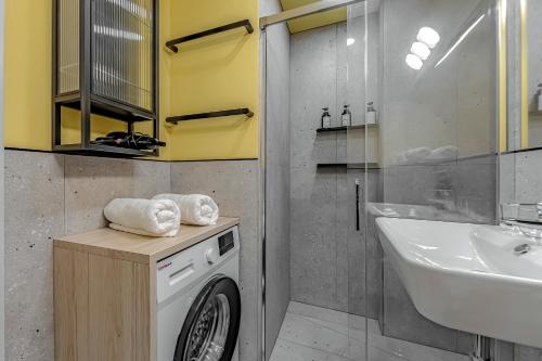 uma casa de banho com uma máquina de lavar roupa e um lavatório em Newly renovated studio 2 min from Playa La Arena em Puerto de Santiago