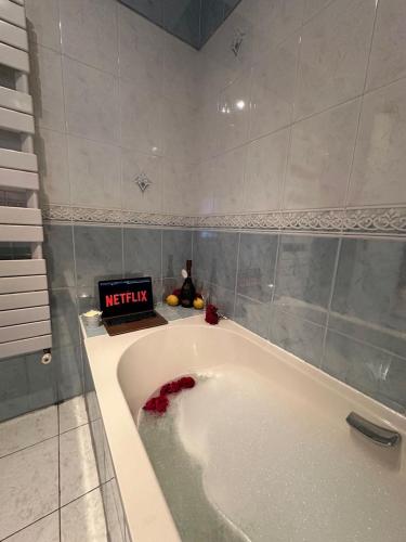 La salle de bains est pourvue d'une baignoire et d'une horloge murale. dans l'établissement Villa - 100 m - Beach - Free Parking, à Villeneuve-Loubet