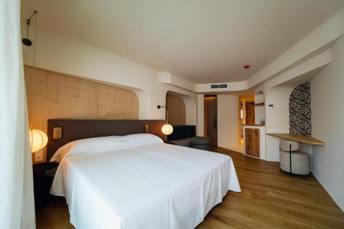 a bedroom with a large white bed in a room at Pacha Hotel in Ibiza Town