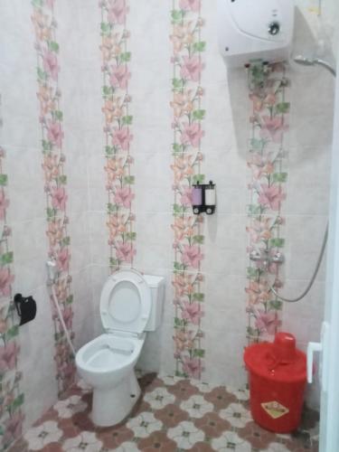 een badkamer met een toilet en een bloemenmand bij VILLA DUMA ORCHID Cipanas in Cipanas