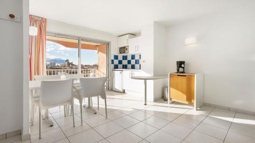 une cuisine et une salle à manger avec une table et des chaises dans l'établissement PRIMAVERA 202 Appt veranda 4 a 6 pers, au Cap d'Agde