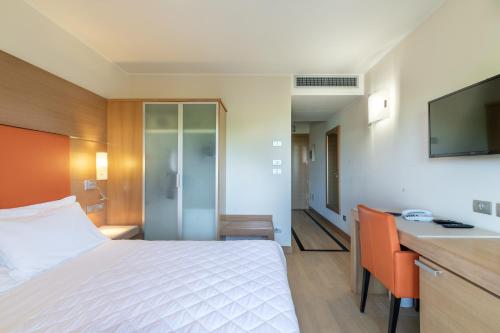 una camera d'albergo con letto e scrivania di Hotel Villa Doimo a Lignano Sabbiadoro