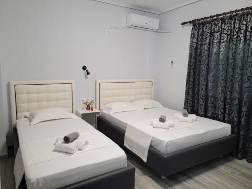 two beds in a hotel room with towels on them at Villa Crystal in Sarandë