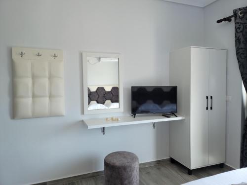 a white room with a tv and a chair at Villa Crystal in Sarandë