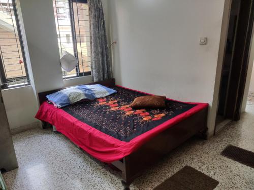 Cama pequeña en habitación con sábana roja en Friend uttara, en Dhaka