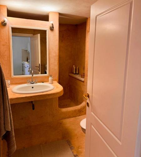 a bathroom with a sink and a toilet and a mirror at Stone Cottage with amazing view in Angairiá