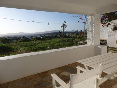 a white room with a bench and a window at Stone Cottage with amazing view in Angairiá