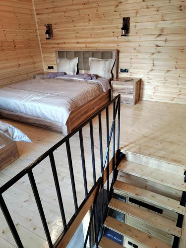 a bedroom in a log cabin with a bed at cottage nikolozi in Stepantsminda