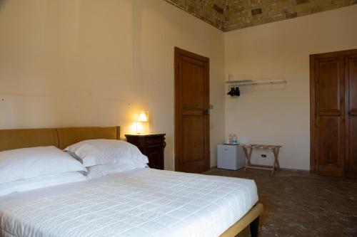a bedroom with a bed and a wooden door at Masseria Celentano Relais & Agriturismo in San Severo