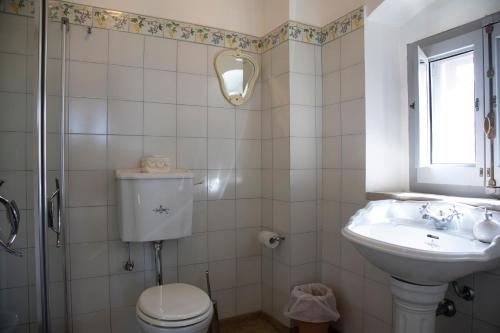a bathroom with a toilet and a sink and a window at Masseria Celentano Relais & Agriturismo in San Severo