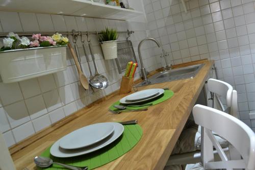 una cucina con bancone, piatti e lavandino di LE QUATTRO MURA EXCLUSIVE a Firenze