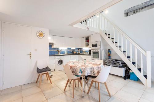 une cuisine avec une table et des chaises ainsi qu'un escalier dans l'établissement Residence naturiste Eden, à Leucate