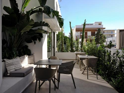 an outdoor patio with tables and chairs and plants at Bond Smart Living Suites in Athens