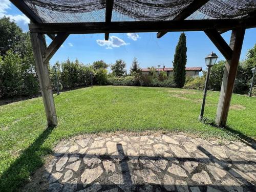 a gazebo with a view of a grass field at 2PoggioValentine Mansion Nature in Scansano