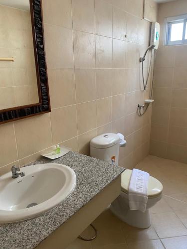 a bathroom with a sink and a toilet and a mirror at NAKA GUEST HOUSE in Ban Ko Kwang