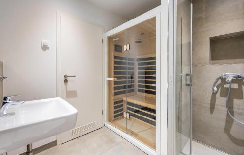 a bathroom with a shower and a sink and a glass shower stall at Apartments Boddenblick in Sagard