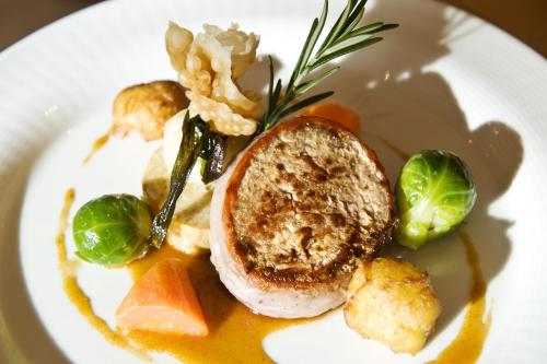 a plate of food with a sandwich and vegetables at Hotel Chalet Tianes - Alpine Relax in Castelrotto