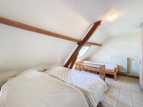 a attic bedroom with two beds and a table at De Eikhoeve - Alveringem in Alveringem