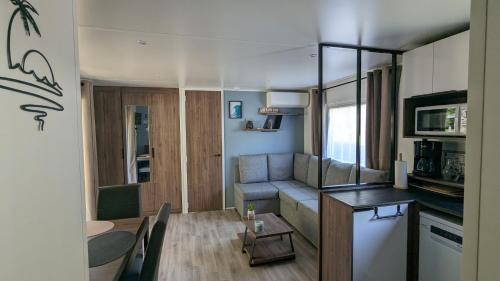 un petit salon avec un canapé et une table dans l'établissement Mobil-home 40m2 au calme, plage, piscine, forêt, à Saint-Julien-en-Born