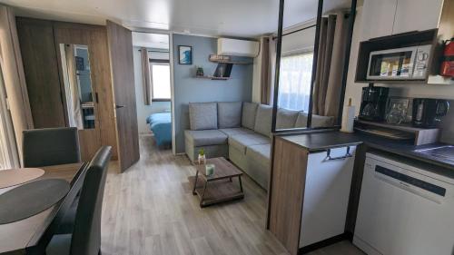 un petit salon avec un canapé et une table dans l'établissement Mobil-home 40m2 au calme, plage, piscine, forêt, à Saint-Julien-en-Born
