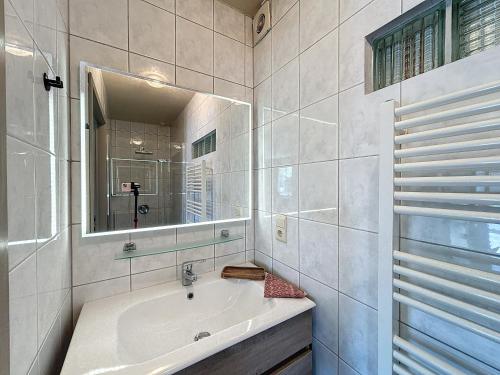a white bathroom with a sink and a mirror at De Eikhoeve - Alveringem in Alveringem