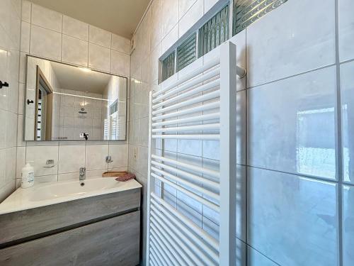 a bathroom with a sink and a mirror at De Eikhoeve - Alveringem in Alveringem