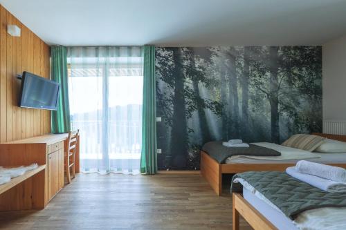 Podjelje的住宿－伯祖卡耶爾卡酒店，一间卧室设有两张床,并拥有一幅树木壁画