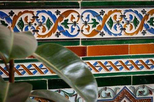 a colorful tile wall with a plant in front of it at Hotel Casa Palacete Tablas by Maxi Hoteles in Granada