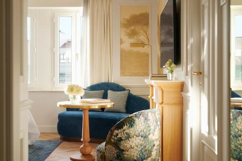 a living room with a blue couch and a table at The Westin Palace, Madrid in Madrid