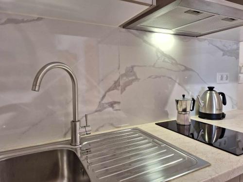 eine Küche mit einer Edelstahlspüle in der Küche in der Unterkunft The Red Dragon in Dassia