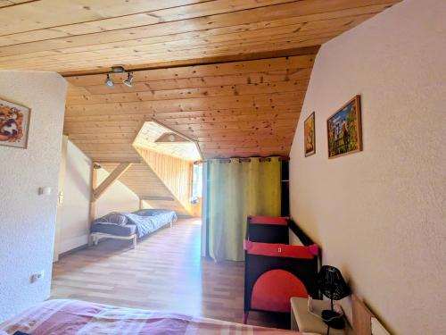 a attic room with a bed and a window at appart proche de la nature in Les Gras