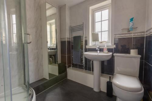 La salle de bains est pourvue de toilettes, d'un lavabo et d'une douche. dans l'établissement Ideal 3 Bed Home In Glasgow City With Free Parking, à Glasgow