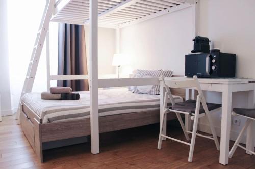 une chambre avec un lit superposé blanc avec un bureau et un bureau dans l'établissement Sacre Coeur Flat, à Paris