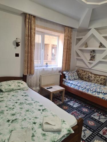 een slaapkamer met een bed en een bank bij CASA CU LAVANDĂ in Vatra Dornei