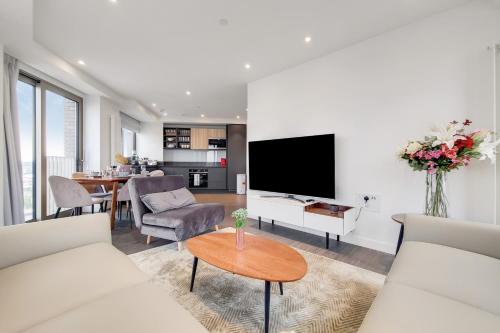 a living room with white furniture and a tv at Deluxe three bedroom Apartment by London ExCeL Stays in London