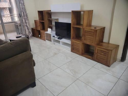 a living room with a couch and a flat screen tv at Appartement Tout Confort en Centre Ville de Kaloum in Conakry